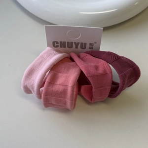 Detail of four gradient pink high-elasticity hair ties with fine ribbed knit texture