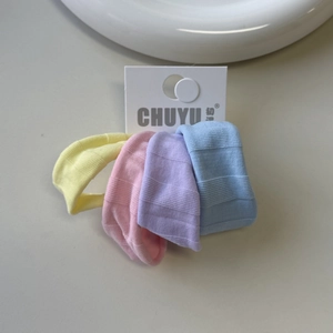 Detailed view of four colorful elastic ice silk hair ties on a white display card