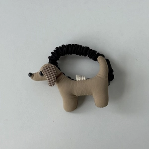 Gros plan sur l'élastique à cheveux chien en peluche marron avec oreilles à carreaux