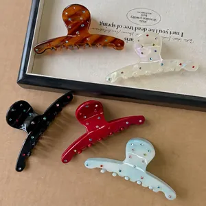 Lot de cinq pinces à cheveux en acétate coloré avec strass brillants dans un plateau