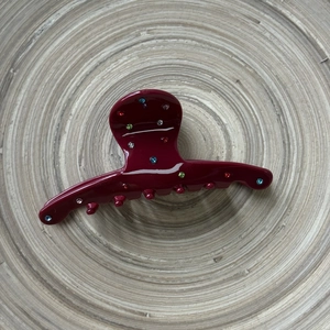 Pince à cheveux élégante en acétate rouge foncé avec strass colorés sur plateau bois