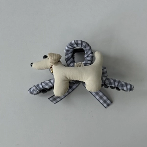Détail d'une pince à cheveux petit chien en peluche avec tissu à carreaux gris et cloche