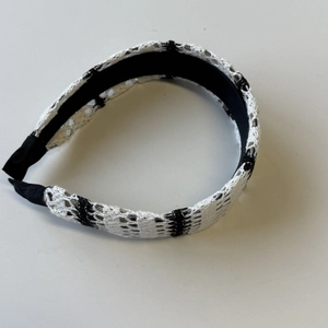 Close-up of crochet hollow knitted stripe headband with black smooth lining for comfort