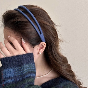 Side view of deep blue double-layered plush headband with soft knit texture on model