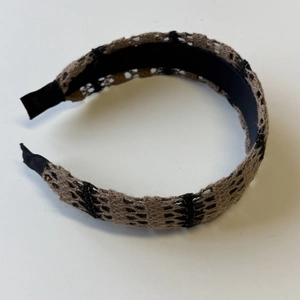 Detailed macro view of vintage brown and black openwork lace knit headband texture