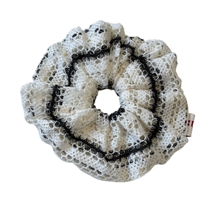 Elegant white lace scrunchie with black wavy stripes and small woven side label