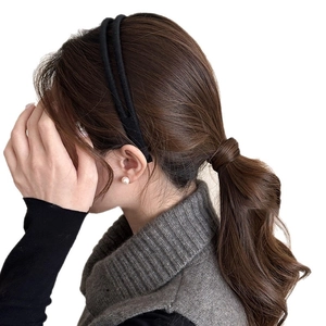 Double-layered black plush headband for women styled with casual knitwear