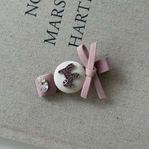 Dettaglio di un fermaglio per capelli con fiocco in raso rosa e strass di cristallo