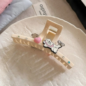 Détail d'une pince à cheveux chat crème ornée de cœurs roses et de strass brillants