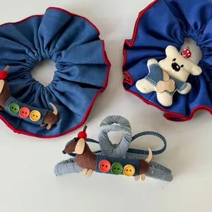 Detalle de coleteros hechos a mano de perro salchicha con botones en tela azul marino