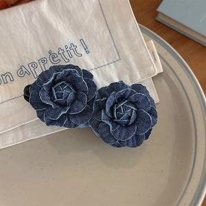 Detailed view of dual blue denim camellia flowers on a high-end vintage hair clip