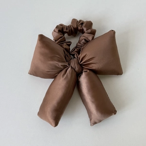 Chouchou nœud papillon marron en satin brillant avec une texture lisse et soyeuse douce