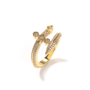 Détail macro de l'épée et croix serties de zircons sur une bague ajustable plaquée or