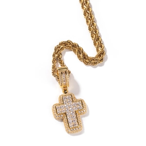 Détail macro du pendentif croix hip-hop doré avec pierres de zircone cubique