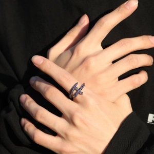 Gros plan sur une bague épée punk rétro avec zircons violets étincelants et fini argent