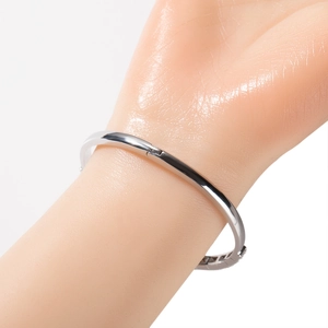 Detailed view of silver minimalist hinged bracelet on model with polished metallic finish
