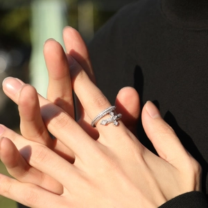 Gros plan d'une bague hip-hop en argent sertie de zircons avec motif croix au doigt