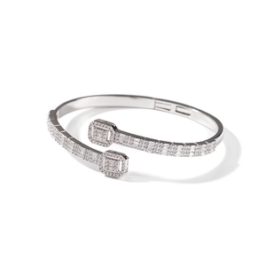 Macro detail of bypass silver bracelet featuring square geometric heads and pavé crystals