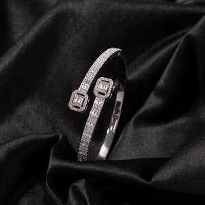 Macro shot of silver bypass bangle with sparkling cubic zirconia on black satin fabric