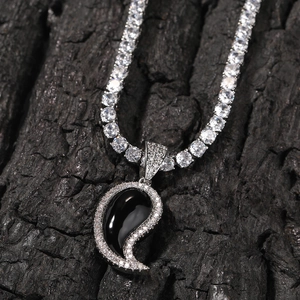 Gros plan d'un pendentif hip hop paisley avec incrustation noire et pavé de zircons blancs