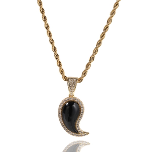 Détail d'un pendentif paisley doré avec pierre noire et zircons blancs sertis