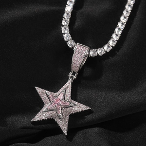 Nahaufnahme des Hip-Hop-Sternanhängers mit rosa Diamanten auf schwarzem Seidenstoff