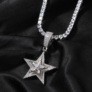 Makroaufnahme von Hip-Hop-Sternanhänger mit Diamanten auf schwarzer Seide