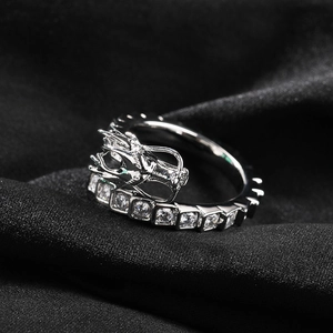 Macro shot of silver dragon ring with cubic zirconia inlay on textured black fabric