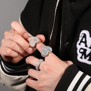 Close-up of hip-hop style heart-shaped and wide band rings with cubic zirconia on hand