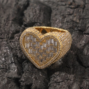 Detailed close-up of heart-shaped gold ring with baguette and round cut zircons