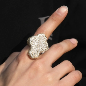 Macro detail of gold plated hip hop ring featuring a cross iced out with zircon stones