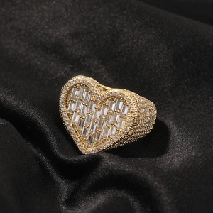 Close-up of golden heart ring featuring baguette-cut zircon and pavé-set crystals