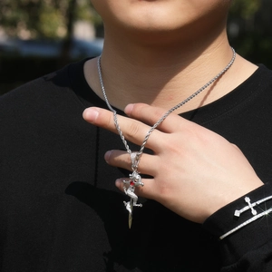 Détail du collier hip-hop argenté avec dragon autour d'une épée et pierre de zircon rouge