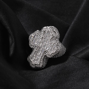 Macro shot of silver hip hop ring with iced out baguette-cut cross and micro pave stones