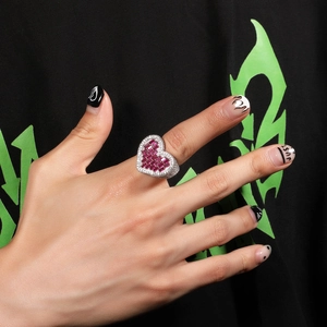 Macro detail of silver heart ring with fuchsia baguette stones and white round zircons