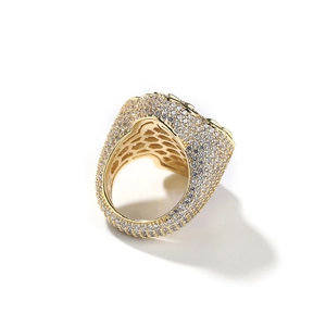 Macro view showing honeycomb cutout detail on gold hip hop ring with paved stones