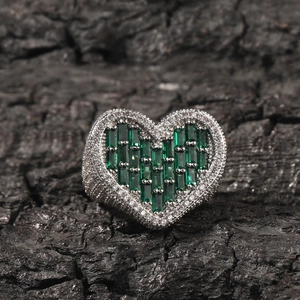 Macro detail of heart-shaped hip-hop ring with green zircon and pavé setting