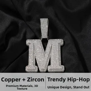 Macro di un ciondolo a lettera M argentato in rame con zirconi stile hip hop chic