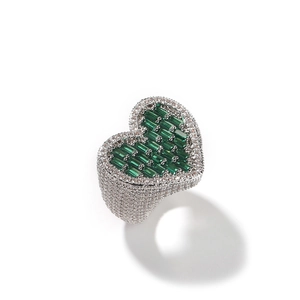 Macro shot of silver ring with green baguette heart gemstone and micro-paved zircon stones