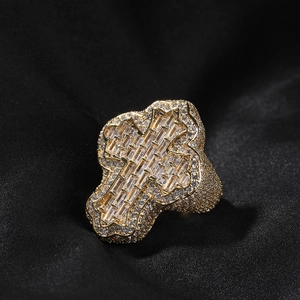 Macro view of gold hip-hop ring featuring cross motif with zircon stones on black silk