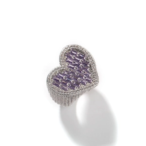 Macro detail of heart-shaped ring with purple baguette-cut stones and iced out pavé diamonds