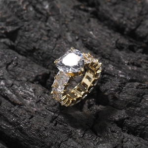 Macro shot of gold heart ring featuring baguette-cut zircon stones on a charcoal background