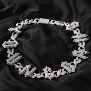 Macro shot of silver hip hop Cuban chain with sparkling zircon stones on black silk