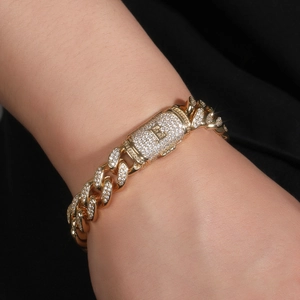 Makroaufnahme von goldenem Panzerarmband mit Buchstabe E und weißen Zirkoniasteinen