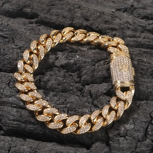 Nahaufnahme eines goldfarbenen Kuba-Armbands mit Zirkonia und H-Verschluss auf Holz