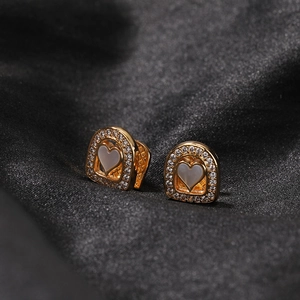 Boucles d'oreilles cœur plaqué or avec nacre et zircons sur fond de soie noire