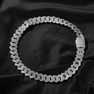 Detailed close-up of 19mm silver Cuban link necklace with pavé zircons on black silk