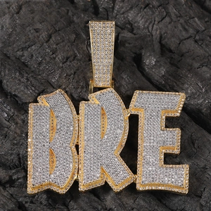 Dettaglio del ciondolo hip-hop lettera BRE placcato in oro con pietre di zircone