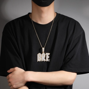 Ciondolo hip hop con lettere BRE e catena a corda dorata indossato su maglia nera