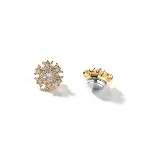 Macro detail of gold snowflake magnetic earrings featuring iced-out cubic zirconia stones